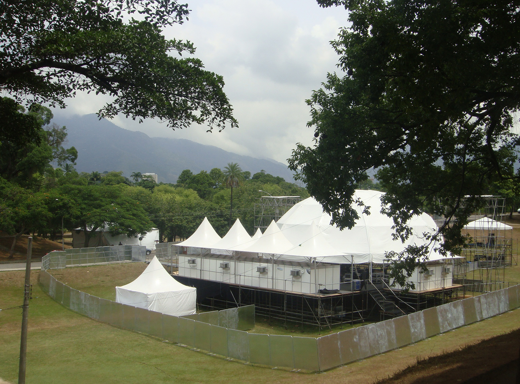 Tenda tipo galpão e tendas chapéu de bruxa cobrindo área de evento